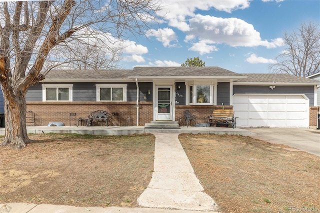 single story home featuring driveway, an attached garage, and brick siding