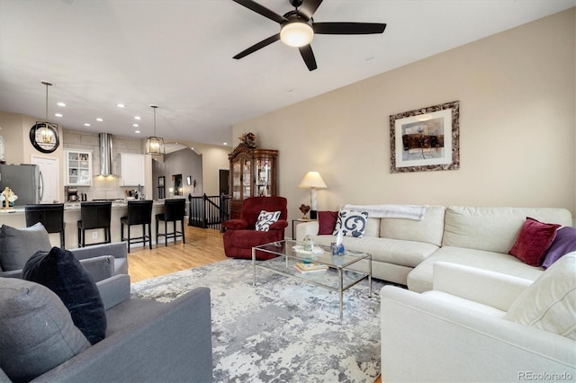 living room featuring ceiling fan and light hardwood / wood-style flooring