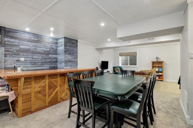 carpeted dining room with wooden walls