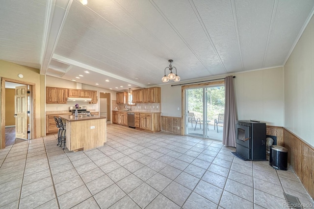 236 Boreen Way, Howard, CO 81233 - kitchen with stainless steel appliances, an island with sink, backsplash, under cabinet range hood, and a wood stove