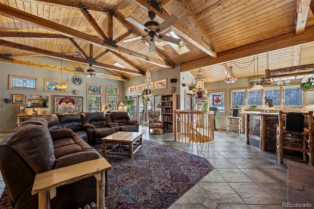 living room with wood ceiling, a ceiling fan, baseboards, beam ceiling, and stone tile flooring
