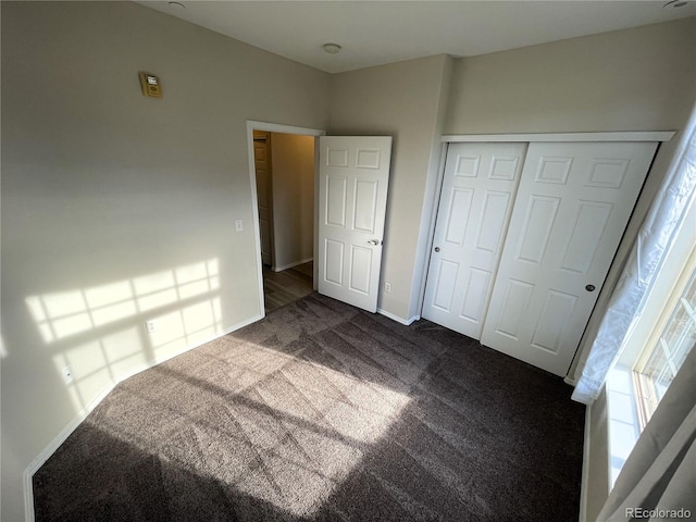 bedroom featuring baseboards, a closet, and dark carpet