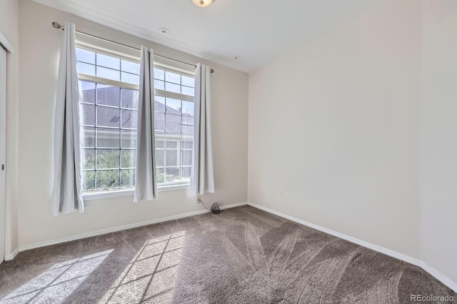 empty room featuring plenty of natural light, baseboards, and carpet