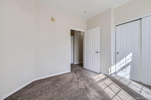 unfurnished bedroom featuring carpet flooring, baseboards, and a closet