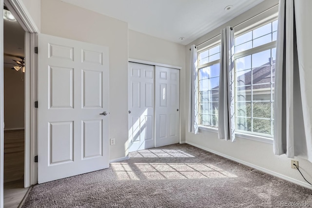 entrance foyer with carpet flooring, plenty of natural light, baseboards, and ceiling fan