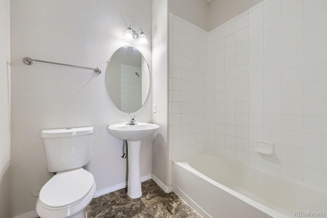 bathroom featuring tub / shower combination, baseboards, toilet, a textured wall, and a sink