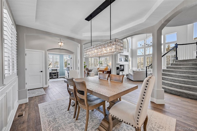 dining space with hardwood / wood-style floors, a notable chandelier, and a tray ceiling