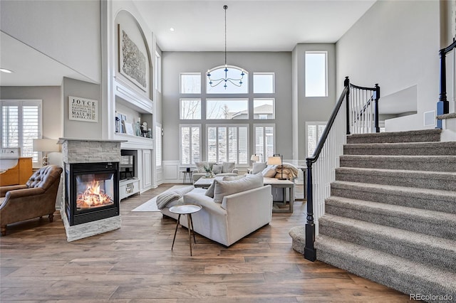 living room with a towering ceiling, hardwood / wood-style floors, and a fireplace