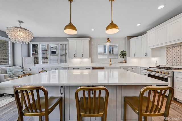 kitchen with white cabinetry, a kitchen island, a kitchen breakfast bar, and hanging light fixtures