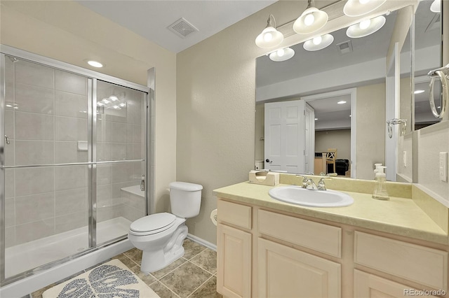 bathroom featuring vanity, tile patterned flooring, toilet, and walk in shower