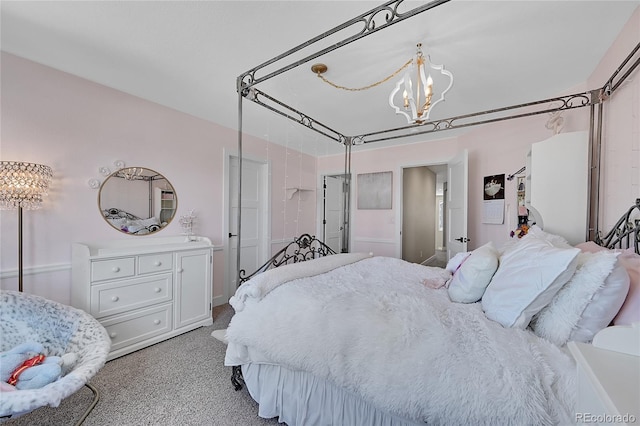 bedroom featuring light colored carpet and a notable chandelier