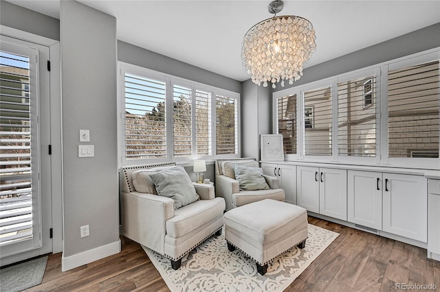 sitting room featuring an inviting chandelier, visible vents, wood finished floors, and baseboards