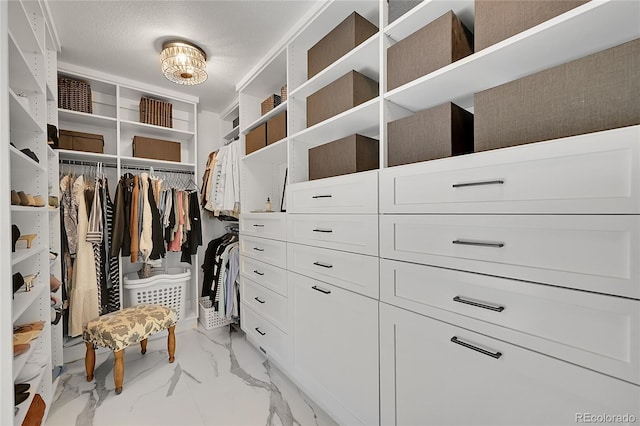 spacious closet with marble finish floor