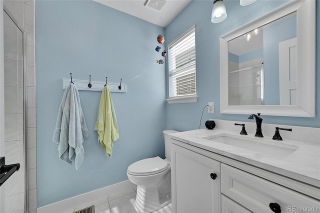 bathroom with toilet, vanity, visible vents, baseboards, and a tile shower
