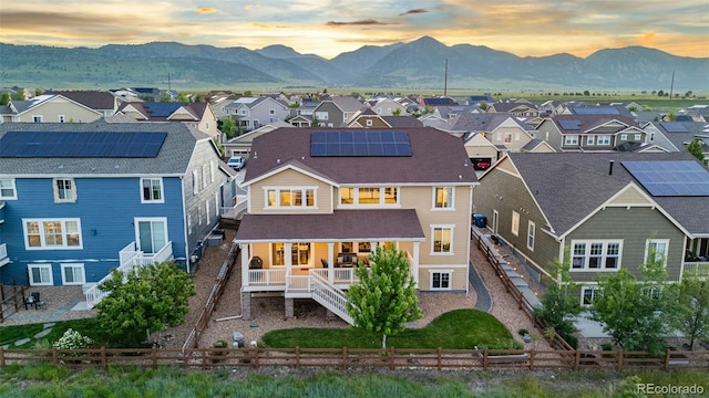 19894 W 94th Ln, Arvada, CO 80007 - back of house at dusk featuring a residential view, a mountain view, a fenced backyard, and stairs