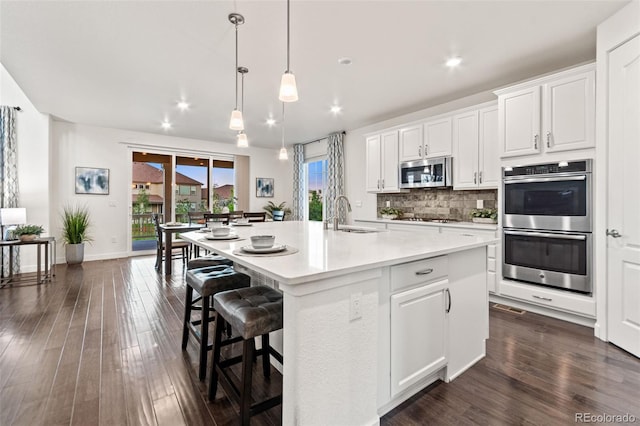 19894 W 94th Ln, Arvada, CO 80007 - kitchen featuring appliances with stainless steel finishes, recessed lighting, tasteful backsplash, dark wood-style floors, and light countertops