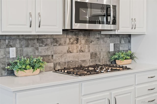 19894 W 94th Ln, Arvada, CO 80007 - kitchen with stainless steel appliances, white cabinetry, backsplash, and light countertops