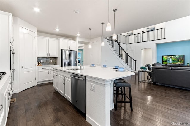 19894 W 94th Ln, Arvada, CO 80007 - kitchen with appliances with stainless steel finishes, open floor plan, dark wood-type flooring, white cabinets, and recessed lighting