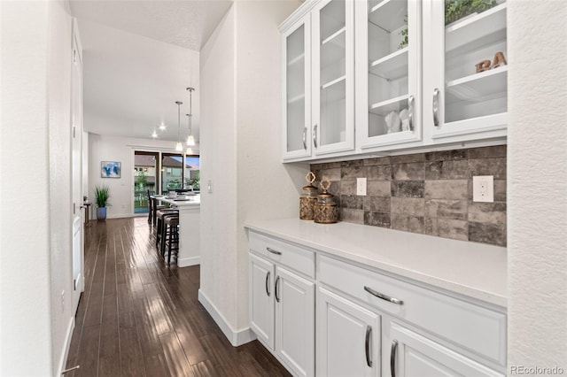 19894 W 94th Ln, Arvada, CO 80007 - bar with backsplash, dark wood-style floors, and pendant lighting