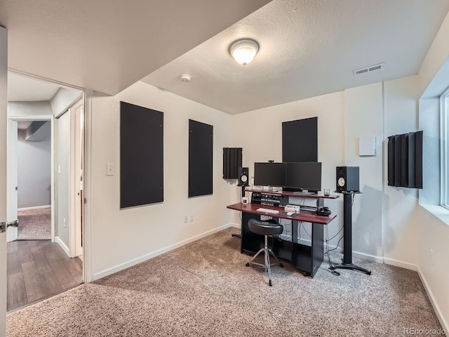 home office featuring carpet floors and a textured ceiling