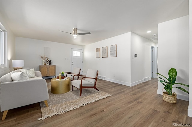 living room featuring visible vents, baseboards, recessed lighting, wood finished floors, and a ceiling fan