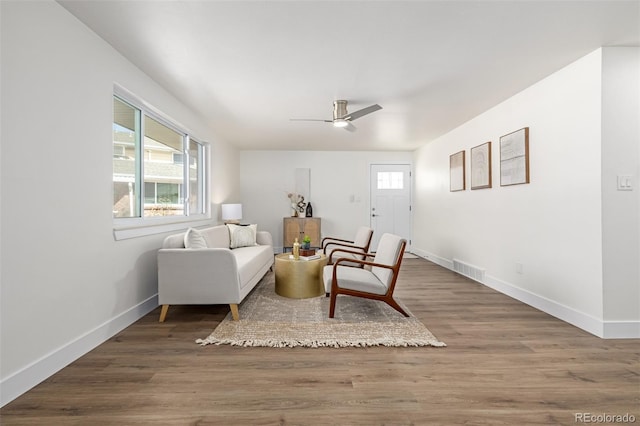 sitting room featuring visible vents, ceiling fan, baseboards, and wood finished floors