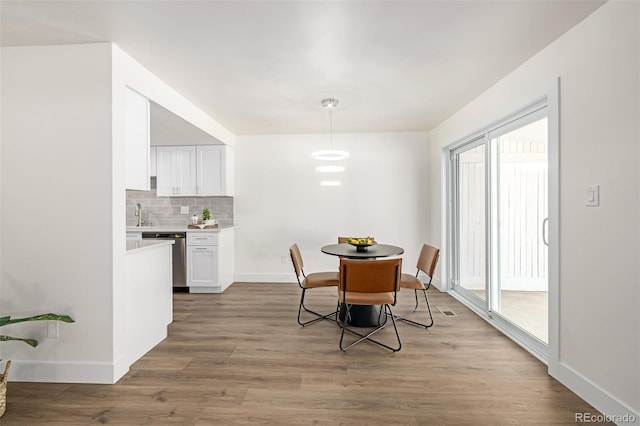 dining space featuring baseboards and wood finished floors