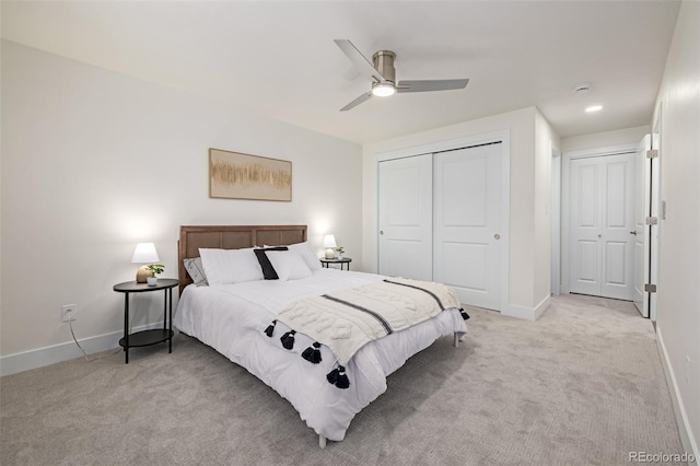 bedroom with a ceiling fan, light colored carpet, baseboards, and a closet