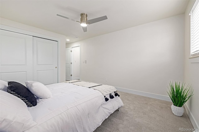 carpeted bedroom featuring a closet, ceiling fan, and baseboards