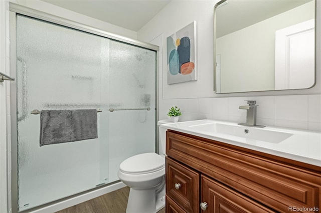 bathroom featuring vanity, toilet, and a stall shower