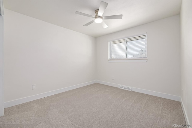 empty room featuring visible vents, baseboards, light colored carpet, and a ceiling fan