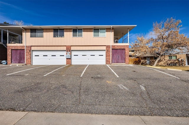 townhome / multi-family property with brick siding and a garage