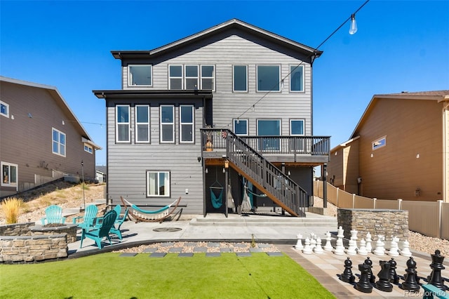 rear view of house featuring a lawn, a patio area, a fire pit, and a deck