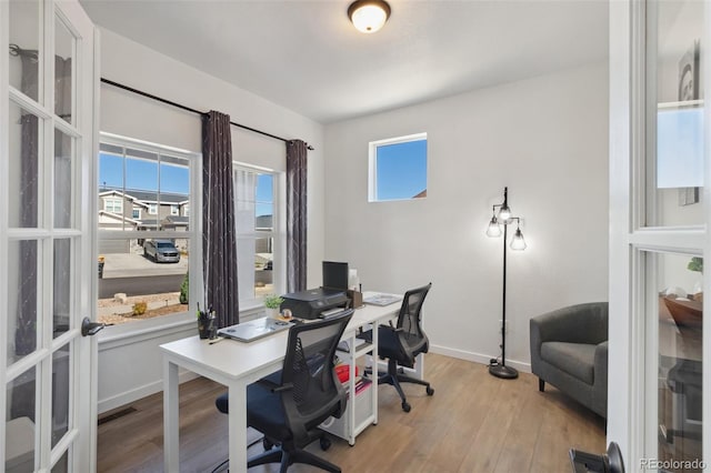 office space with light wood-type flooring and french doors