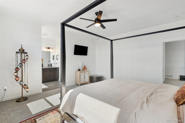 carpeted bedroom with ensuite bath and ceiling fan