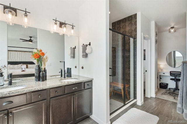 bathroom with ceiling fan, a shower with door, and vanity