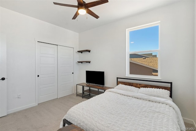 carpeted bedroom featuring ceiling fan and a closet