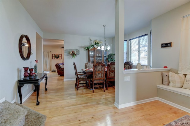 dining space with an inviting chandelier and light hardwood / wood-style floors