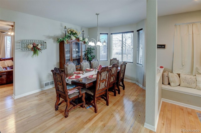 dining area with a notable chandelier and light hardwood / wood-style floors