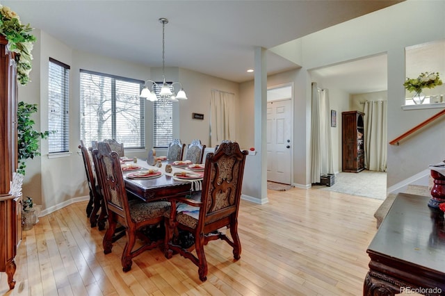 dining space featuring light hardwood / wood-style floors and a notable chandelier