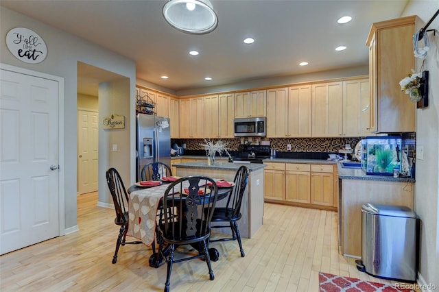 kitchen featuring light brown cabinetry, backsplash, light wood-type flooring, and appliances with stainless steel finishes