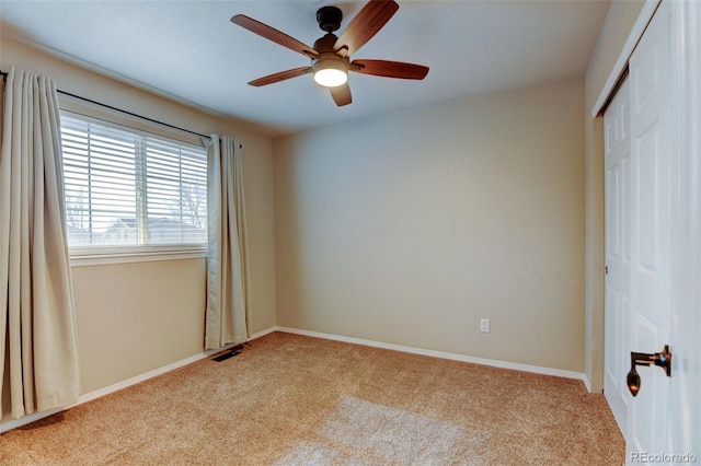 unfurnished bedroom with light colored carpet, ceiling fan, and a closet