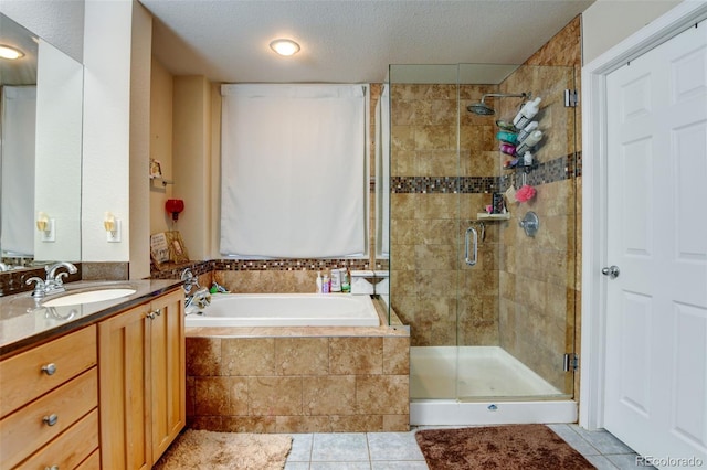 bathroom with tile patterned flooring, vanity, plus walk in shower, and a textured ceiling