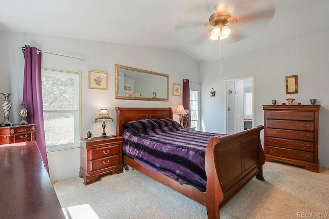 bedroom featuring ceiling fan, light colored carpet, lofted ceiling, and ensuite bathroom