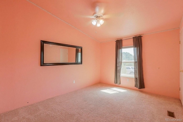 carpeted spare room with ceiling fan and vaulted ceiling