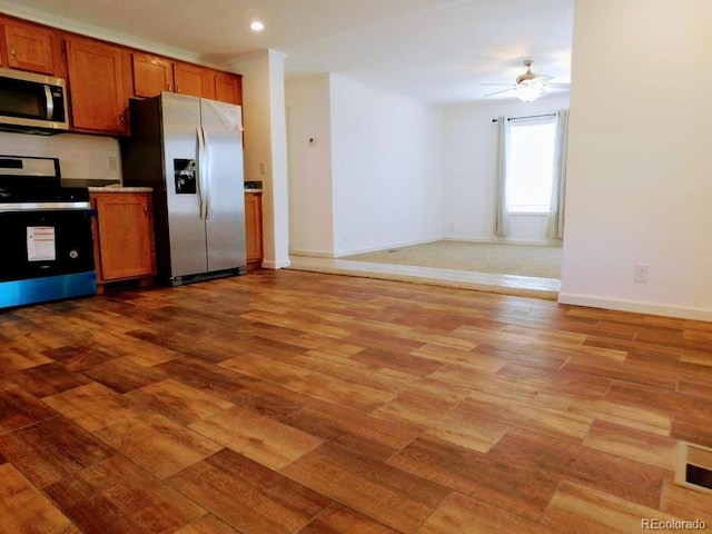 kitchen featuring stainless steel appliances, light wood-type flooring, and ceiling fan