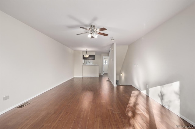 unfurnished living room featuring ceiling fan and dark hardwood / wood-style flooring