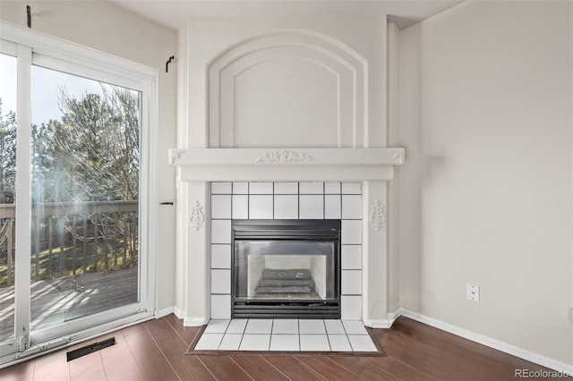 room details featuring a tile fireplace and hardwood / wood-style flooring