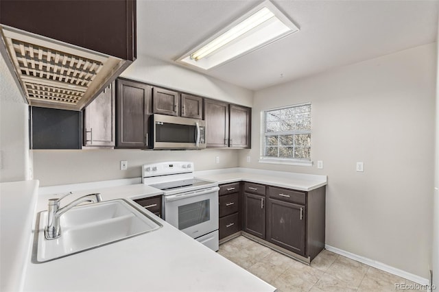 kitchen featuring white electric range oven, dark brown cabinetry, and sink