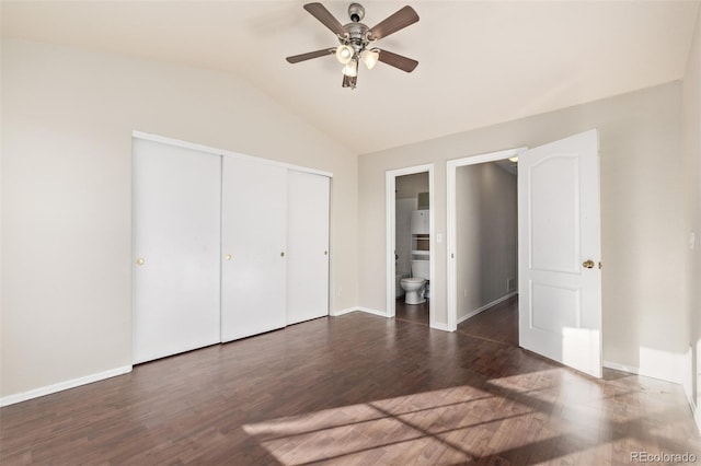 unfurnished bedroom with vaulted ceiling, ceiling fan, dark hardwood / wood-style floors, connected bathroom, and a closet